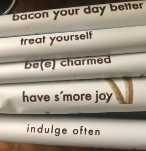 Candy labels reading: bacon your day better, treat yourself, be(e0 charmed, have s'more joy, and indulge often.